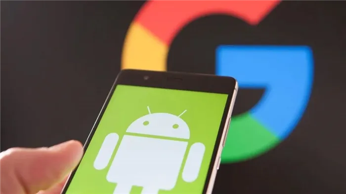Android на рабочем столе смартфона в руке пользователя с логотипом Google на заднем плане