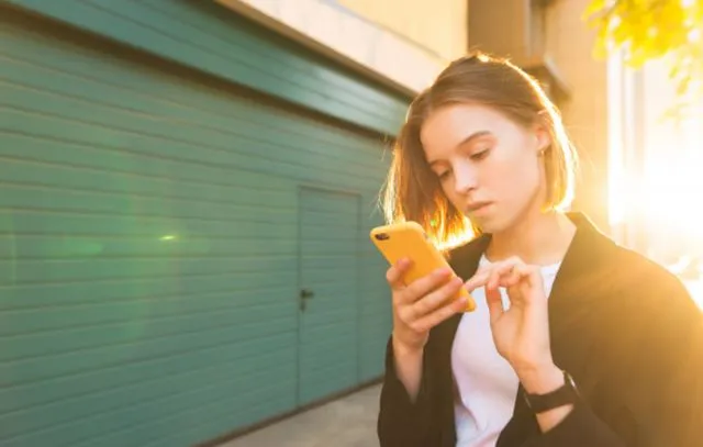 Портрет деловой женщины со смартфоном в руке под солнцем